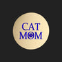A round, brushed gold metal sticker featuring the text 'CAT MOM' in bold blue lettering, with a blue paw print icon replacing the letter 'O', set against a plain white background.