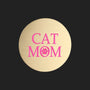 A round, brushed gold metal sticker featuring the text 'CAT MOM' in bright pink, with a paw print icon inside the letter 'O', set against a plain white background.