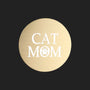 A round, brushed gold metal sticker featuring the words 'CAT MOM' in white, with a paw print icon inside the letter 'O', set against a plain white background.