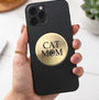 A round, brushed gold metal plaque featuring the text 'CAT MOM' in black, with the letter 'O' replaced by a black paw print icon, shown on a plain white background.