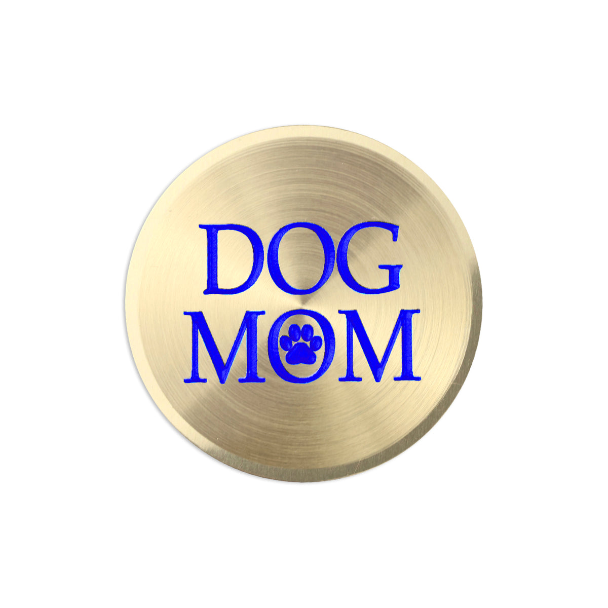 A round, brushed gold metal sticker  featuring the text 'DOG MOM' in bold blue lettering, with a blue paw print icon replacing the letter 'O'.