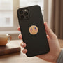 Metal Stickems American flag emblem sticker applied to a black smartphone case held in a hand.