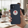 Metal Stickems round American Red Cross metal sticker applied to a dark blue smartphone case in an office setting.