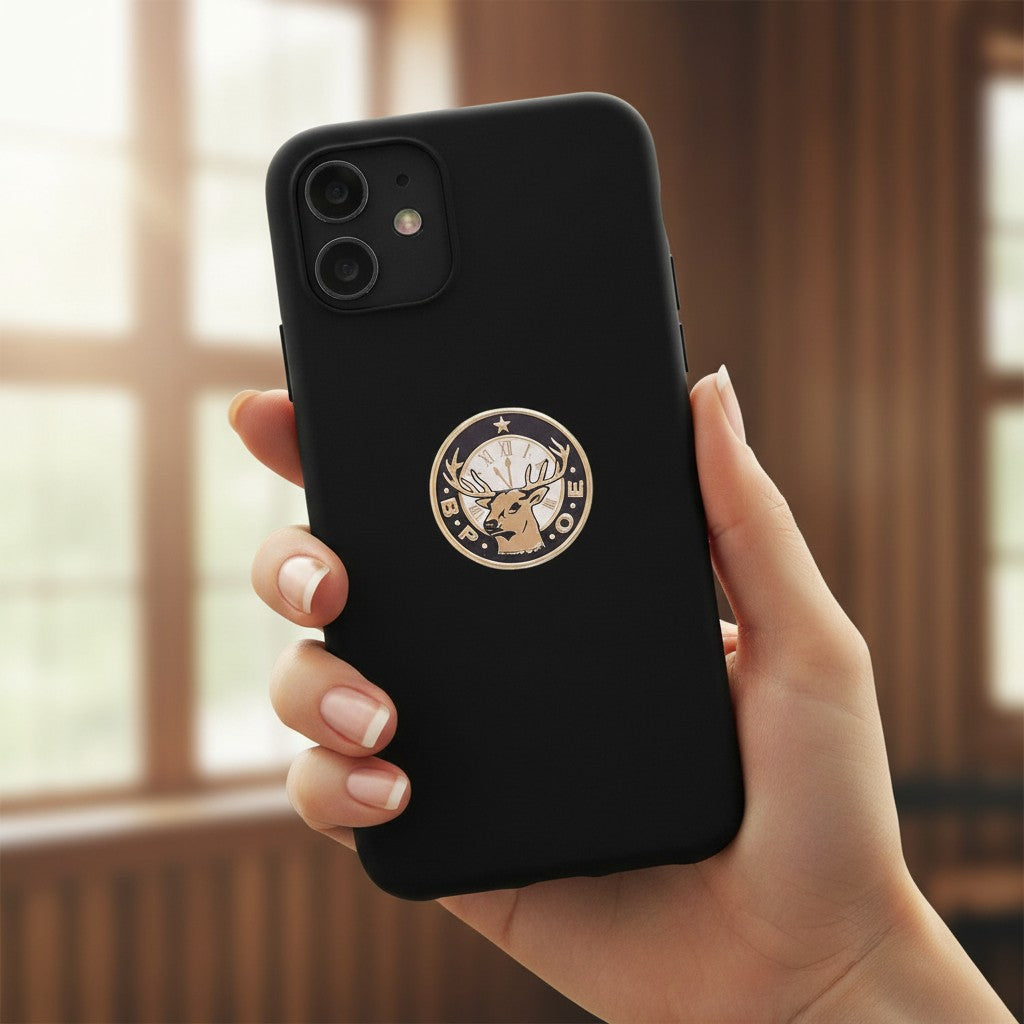 Metal Stickems 7/8 inch B.P.O.E. metal sticker with stag head and clock face on a black smartphone case