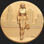 Metal Stickems round gold-tone adhesive sticker featuring an embossed businesswoman walking in front of a city skyline.