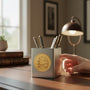 Metal Stickems card table decorative metal emblem sticker applied to a silver pen holder on a wooden desk.