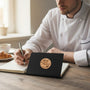 Metal Stickems chef hat culinary metal sticker on a black notebook held by a chef in a professional kitchen