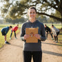 Metal Stickems coach themed metal sticker on a clipboard held by a female coach at a sports practice field