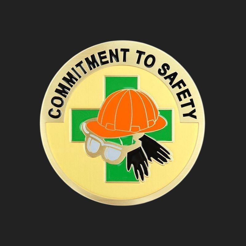 Metal Stickems 2-inch round metal safety sticker with hard hat, glasses, and gloves icon on a gold background.