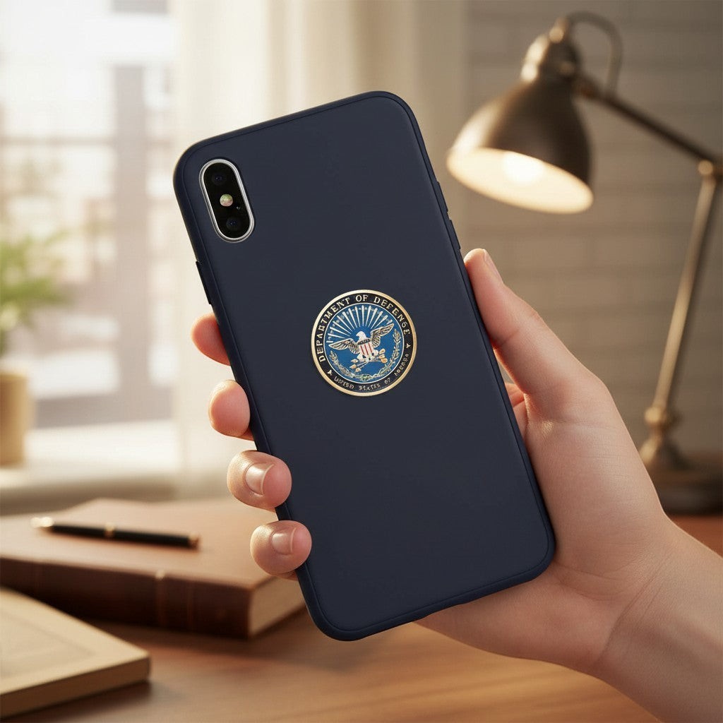 Metal Stickems Department of Defense metal emblem sticker applied to the back of a dark blue smartphone case.