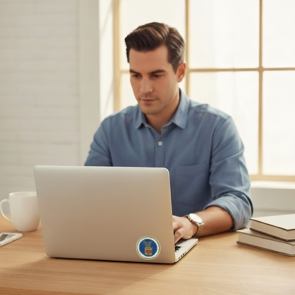 Man working on a laptop with a 2-inch Metal Stickems Department of Labor metal emblem sticker applied to the lid.
