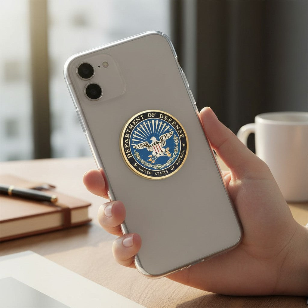 Metal Stickems 2-inch Department of Defense metal emblem sticker applied to the back of a clear smartphone case.