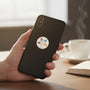 Metal Stickems Order of the Eastern Star emblem sticker applied to the back of a black smartphone.