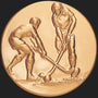 Metal Stickems 2-inch round gold-tone metal sticker featuring an embossed field hockey players action design.