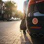 Metal Stickems 2-inch volunteer firefighter Maltese cross emblem decal in red, black, and gold on a car bumper.