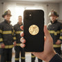 Metal Stickems firefighter themed metal sticker on a black smartphone case with blurred firefighters in background