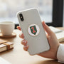 Metal Stickems 1st Infantry Division metal emblem sticker applied to the back of a smartphone held in a hand.