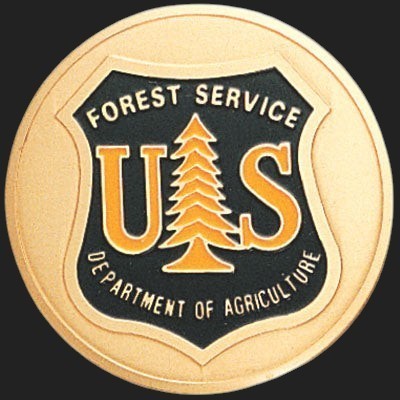 Metal Stickems 2-inch gold and black US Forest Service metal adhesive emblem with iconic pine tree shield design.
