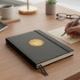 Metal Stickems academic achievement award sticker in gold with lamp of knowledge design on a black notebook cover