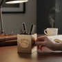 Metal Stickems gold academic achievement sticker featuring embossed learning symbols on a desk pen holder