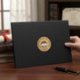 Metal Stickems 2-inch gold metal award sticker with book and torch motif on a black certificate folder