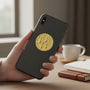 Metal Stickems gold embossed chess board sticker applied to a black smartphone held in a hand.