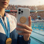 Metal Stickems 2-inch gold diving athlete sticker applied to a smartphone held by an athlete wearing a gold medal.