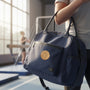 Metal Stickems gold gymnastics decal applied to a blue gym bag in a training studio
