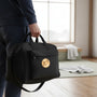 Metal Stickems gold martial arts embossed metal sticker on a black gym bag held by a person in a studio