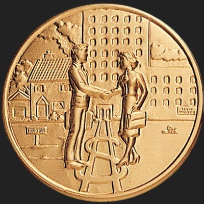Metal Stickems 2-inch gold commemorative coin sticker featuring an embossed handshake and real estate architecture.
