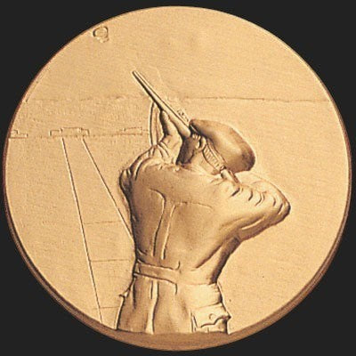 Metal Stickems 2-inch round gold-tone adhesive emblem featuring an embossed skeet shooter aiming a shotgun.