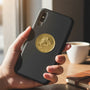 Metal Stickems 2-inch gold embossed snowboarder sticker applied to a black smartphone case