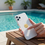 Metal Stickems gold embossed swimmer sticker applied to the back of a white smartphone by a pool.