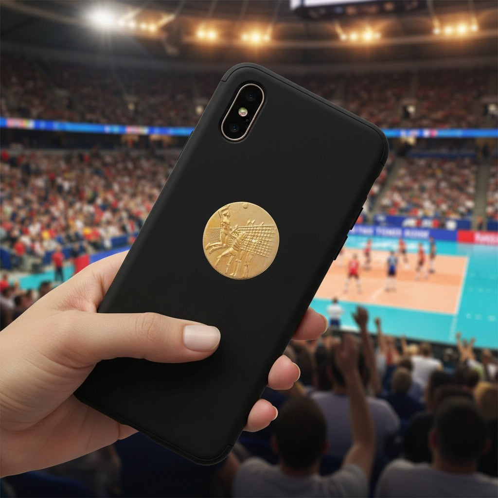 Metal Stickems 1 inch gold volleyball metal sticker applied to a black smartphone case in a stadium setting