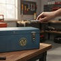Metal Stickems 2-inch Military Police Corps metal emblem sticker applied to a blue metal toolbox in a workshop.