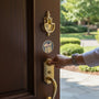 Metal Stickems 2-inch round patriotic sticker with gold and grey American flag design applied to a wooden door.