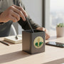 Metal Stickems round gold and green Peak Performance sticker featuring a star and mountain design on a desk cup.