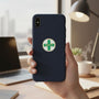 Metal Stickems 7/8 inch safety cross sticker with green cross and gold border applied to a dark blue phone case.