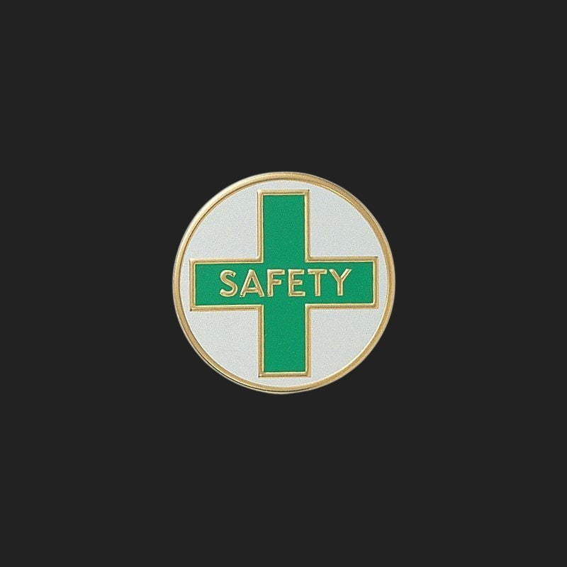 Metal Stickems 7/8 inch round safety emblem with a green cross, white background, and gold-tone border.