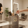 Metal Stickems 2-inch circular metal sticker with hair salon motif applied to a stainless steel tool holder in a salon.
