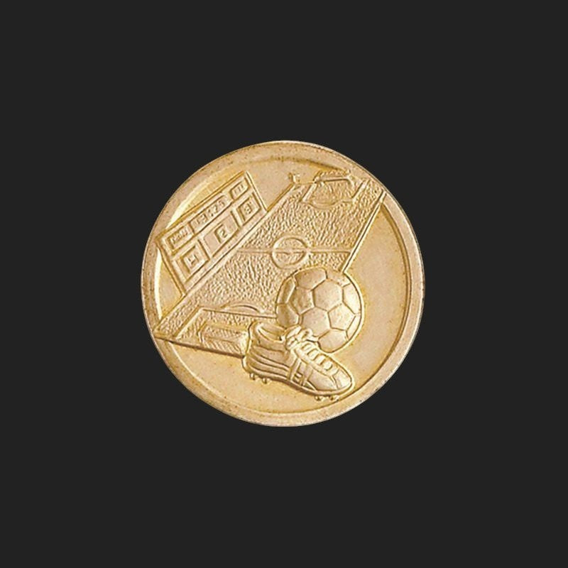 Metal Stickems 1-inch gold-toned metal sticker featuring an embossed soccer field, ball, and cleat design.