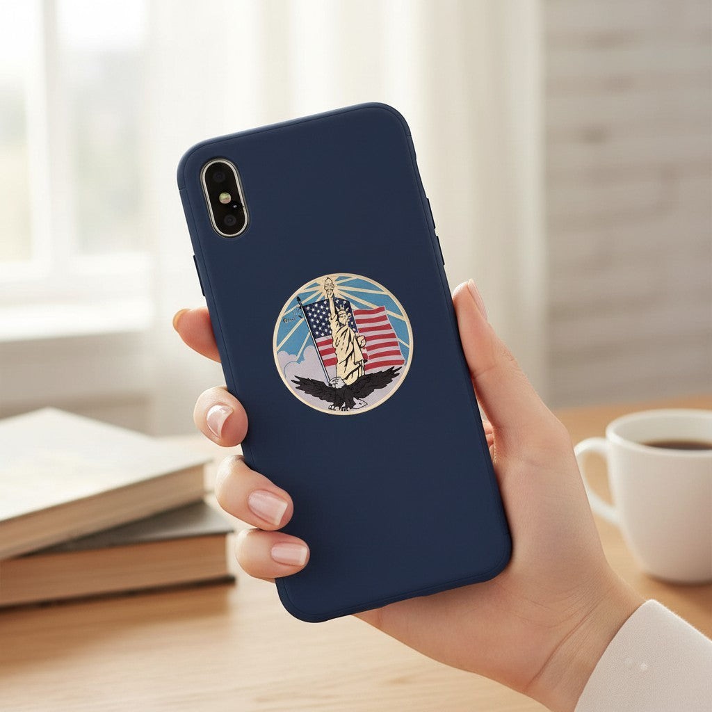 Metal Stickems patriotic Statue of Liberty metal sticker on a navy blue smartphone case held in a hand.