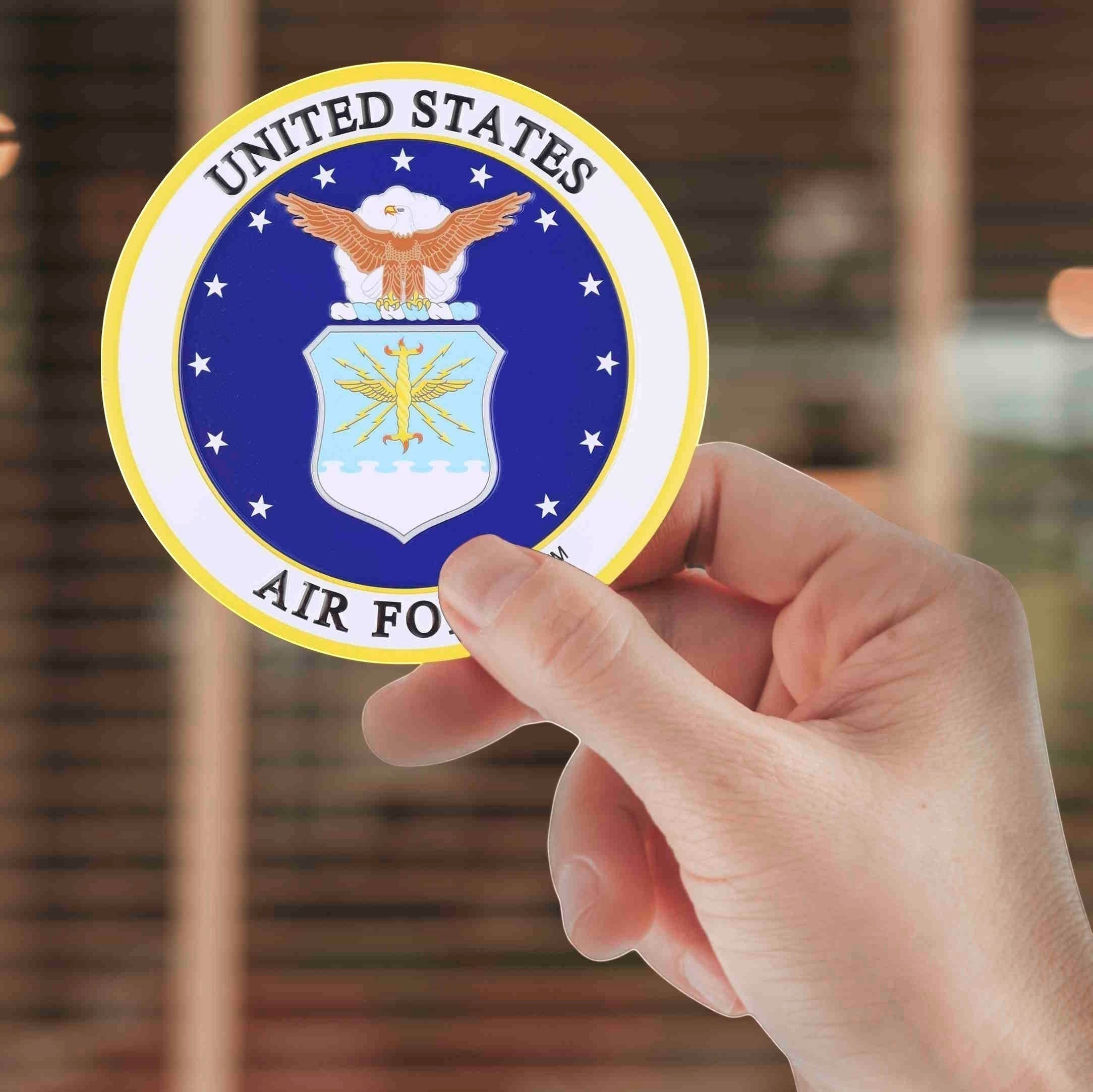 Metal Stickems 4-inch embossed brass United States Air Force round peel-and-stick medallion held in a hand.
