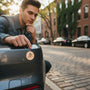 Metal Stickems United States Army metal emblem sticker applied to a car bumper with a man looking on in an urban setting.