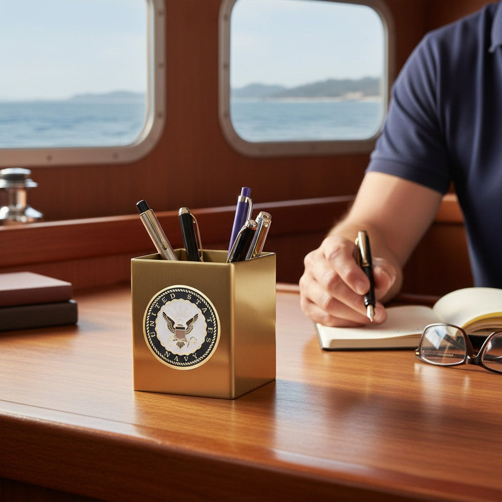Metal Stickems 2-inch United States Navy emblem sticker in gold, black, and white applied to a gold desk pen holder.