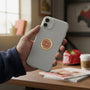 Metal Stickems volunteer firefighter Maltese cross emblem in gold and red applied to the back of a smartphone.